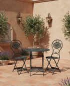 Outdoor patio set with table and chairs on a tiled floor against a wall with potted plants and a water feature.