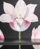 Decorative paper flower with pink and white petals on a black background