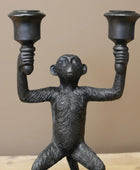 Black monkey-shaped candle holder against a teal background
