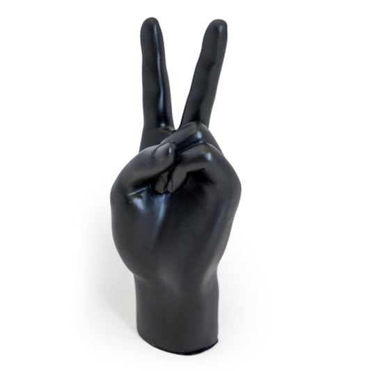 A glossy black hand sculpture or decorative object shaped like a human hand making a peace sign, photographed against a plain white background.