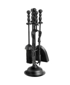 Black fireplace tool set with broom, shovel, and tongs on a white background