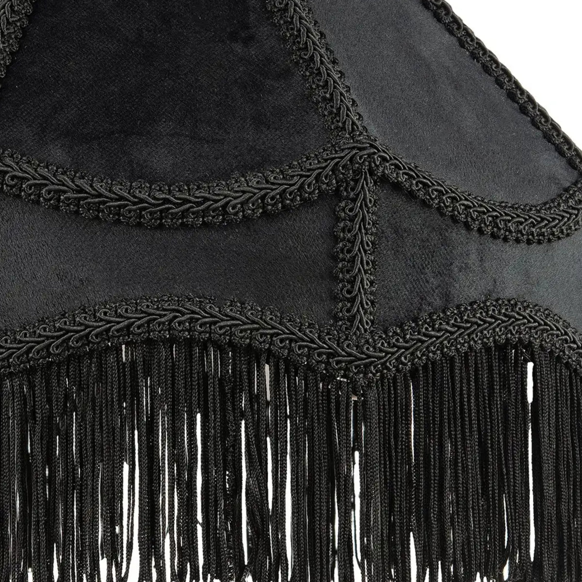 Close-up of a black fringed textile accessory with braided trim and hanging fringe, shown against a white background.