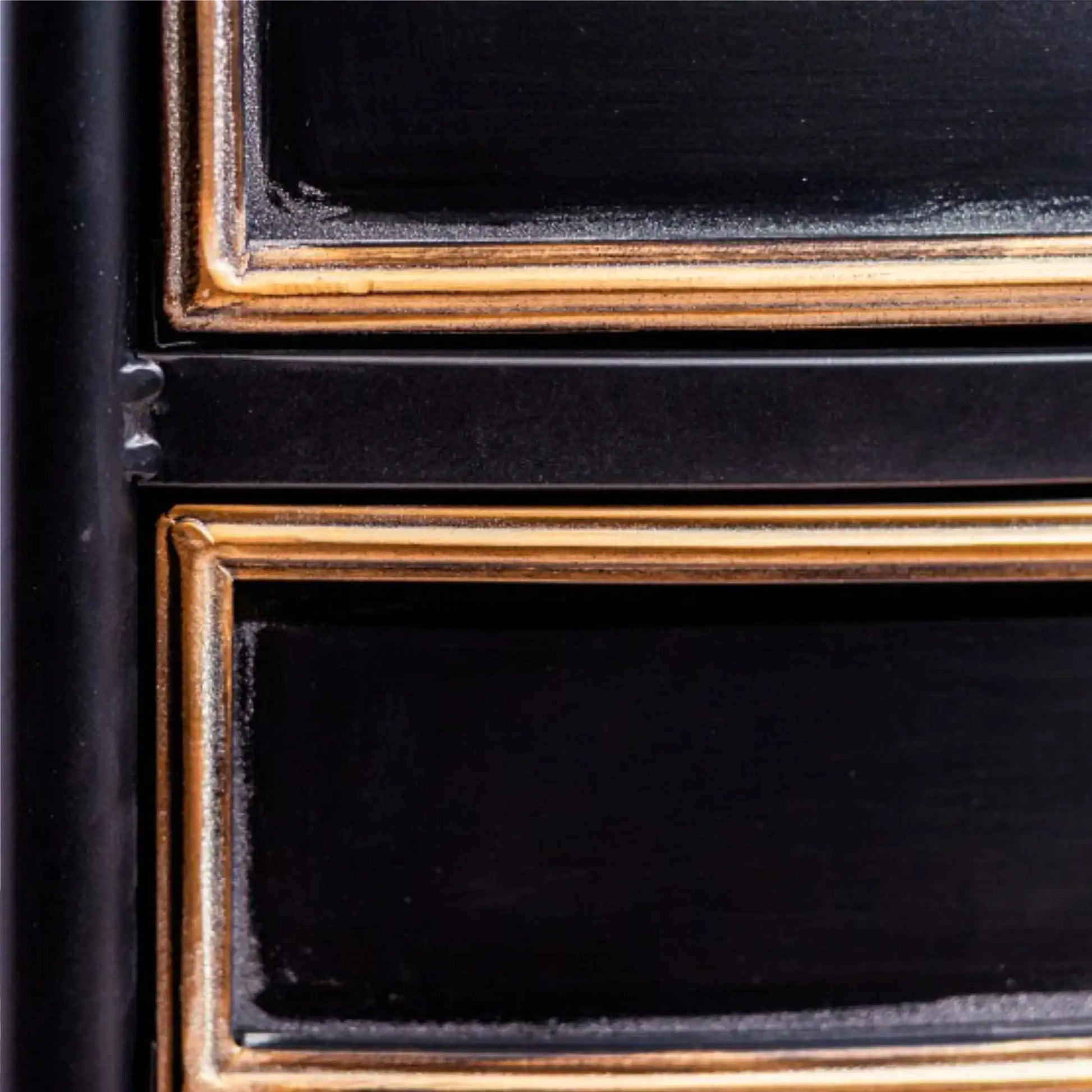 Close-up of a black and gold frame with a textured border