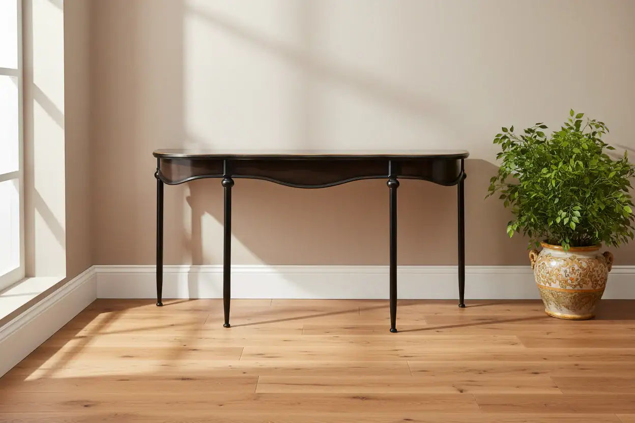 Dark wooden table against a beige wall with a potted plant on a wooden floor.