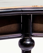 Close-up of a black metal object with a detailed design on a light gray background