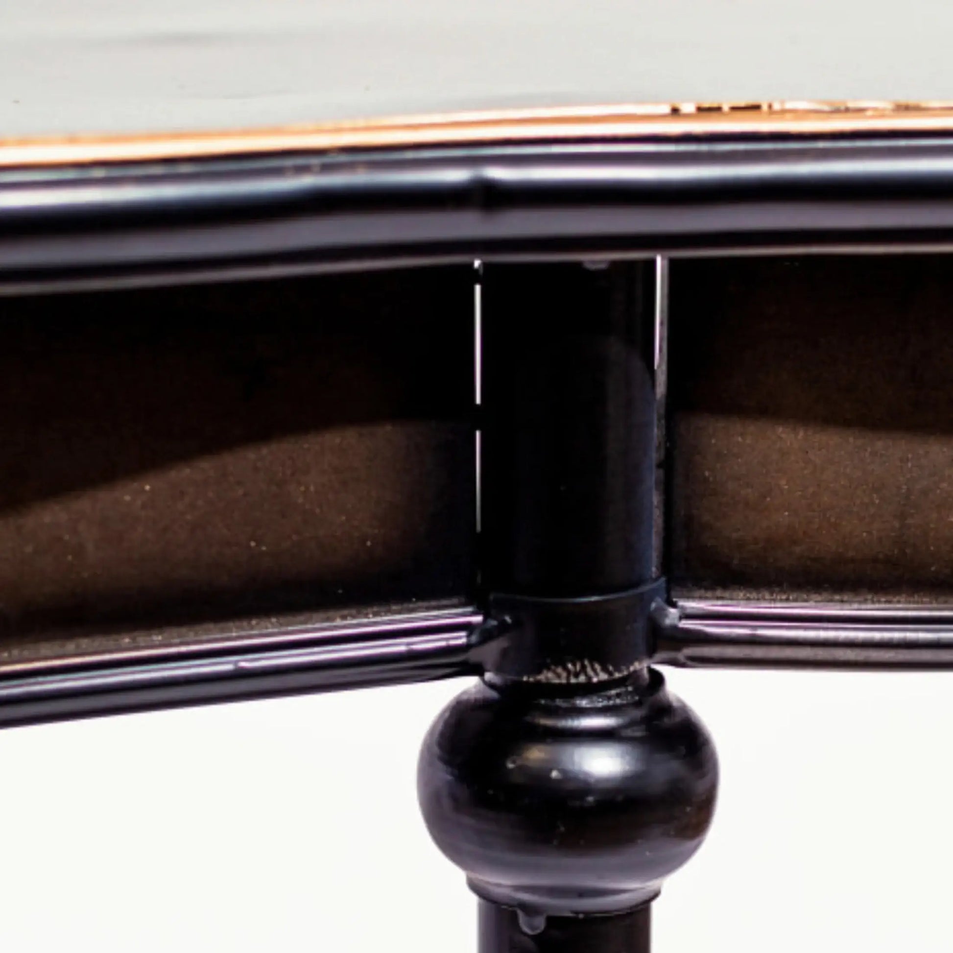 Close-up of a black metal object with a detailed design on a light gray background