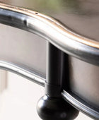 Close-up of a metal chair arm with a blurred background