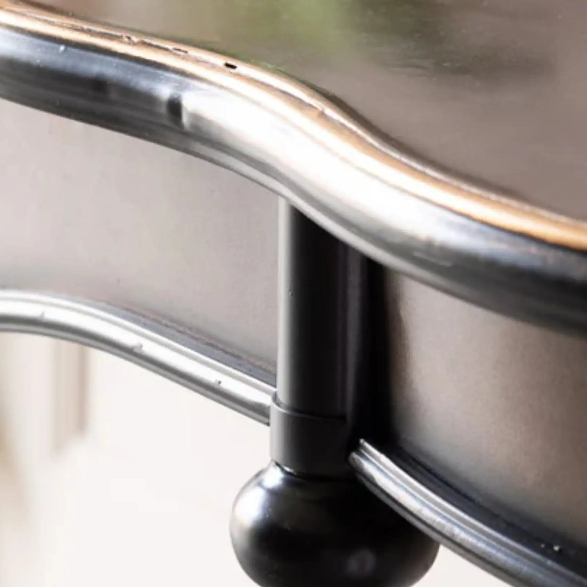 Close-up of a metal chair arm with a blurred background