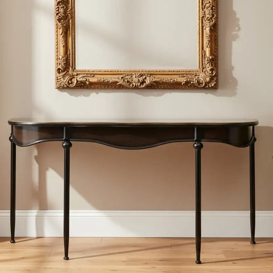 Dark wooden console table against a beige wall with an ornate gold frame.