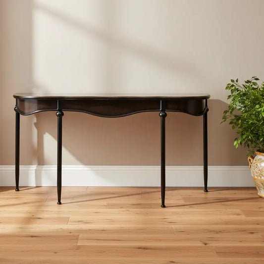 Dark wooden console table against a beige wall with a plant on a wooden floor.