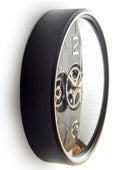 Wall clock with black casing and visible gears on a white background