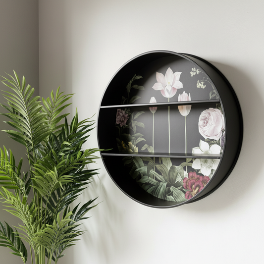 Round black wall shelf with floral design on a white wall