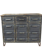 Industrial-style metal dresser with multiple drawers against a brick wall.