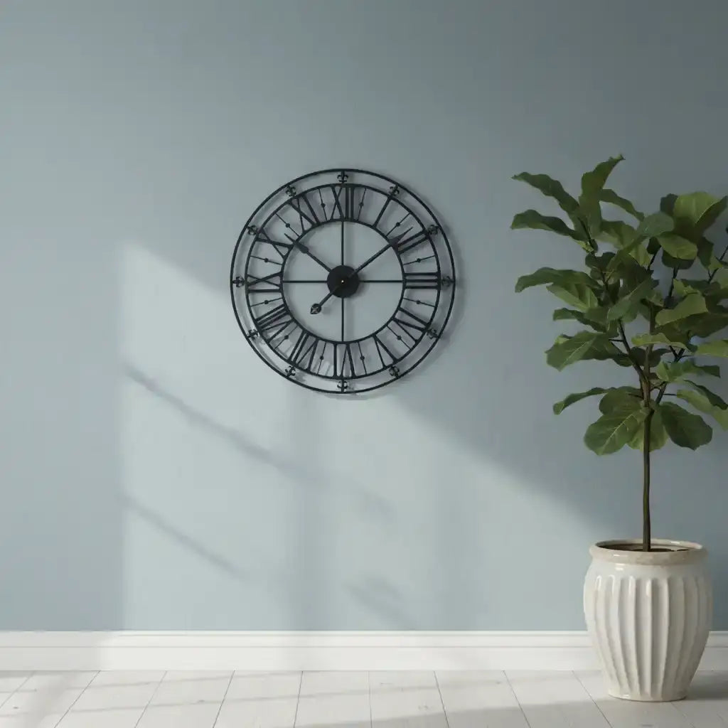 Decorative wall clock on a light blue wall with a potted plant below.