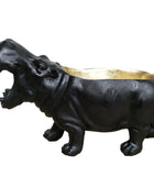 Black hippo-shaped planter with a gold interior on a wooden surface