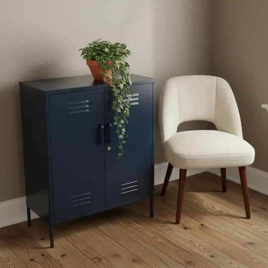 Navy blue metal cabinet with a plant next to a beige chair on a wooden floor.