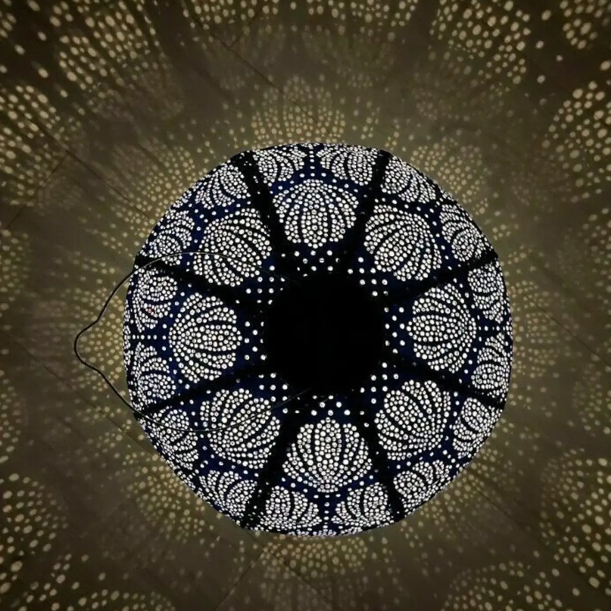 Decorative circular light fixture casting a pattern on a wall