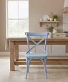 Light blue chair in front of a wooden dining table in a kitchen setting.