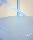 Light blue mattress cover on a bed with a beige wall in the background