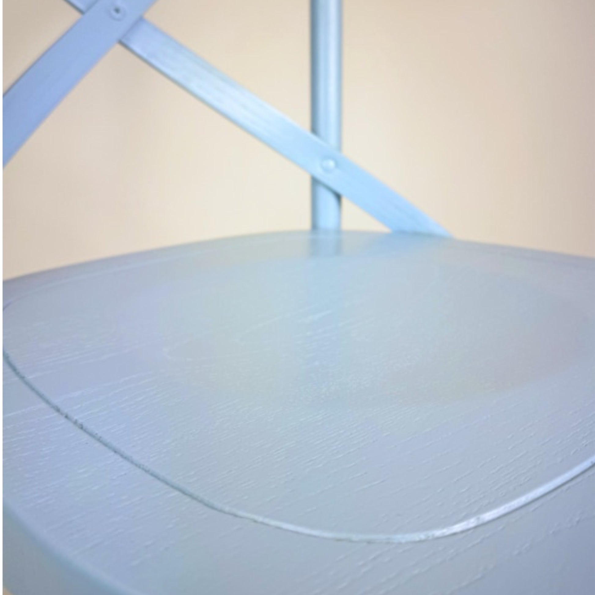 Light blue mattress cover on a bed with a beige wall in the background