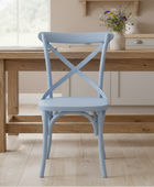 Light blue chair in front of a wooden dining table with a vase of flowers on a kitchen counter.