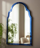 Decorative mirror with blue frame on a wooden surface