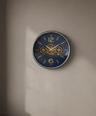 Decorative wall clock on a beige wall with a plant to the right