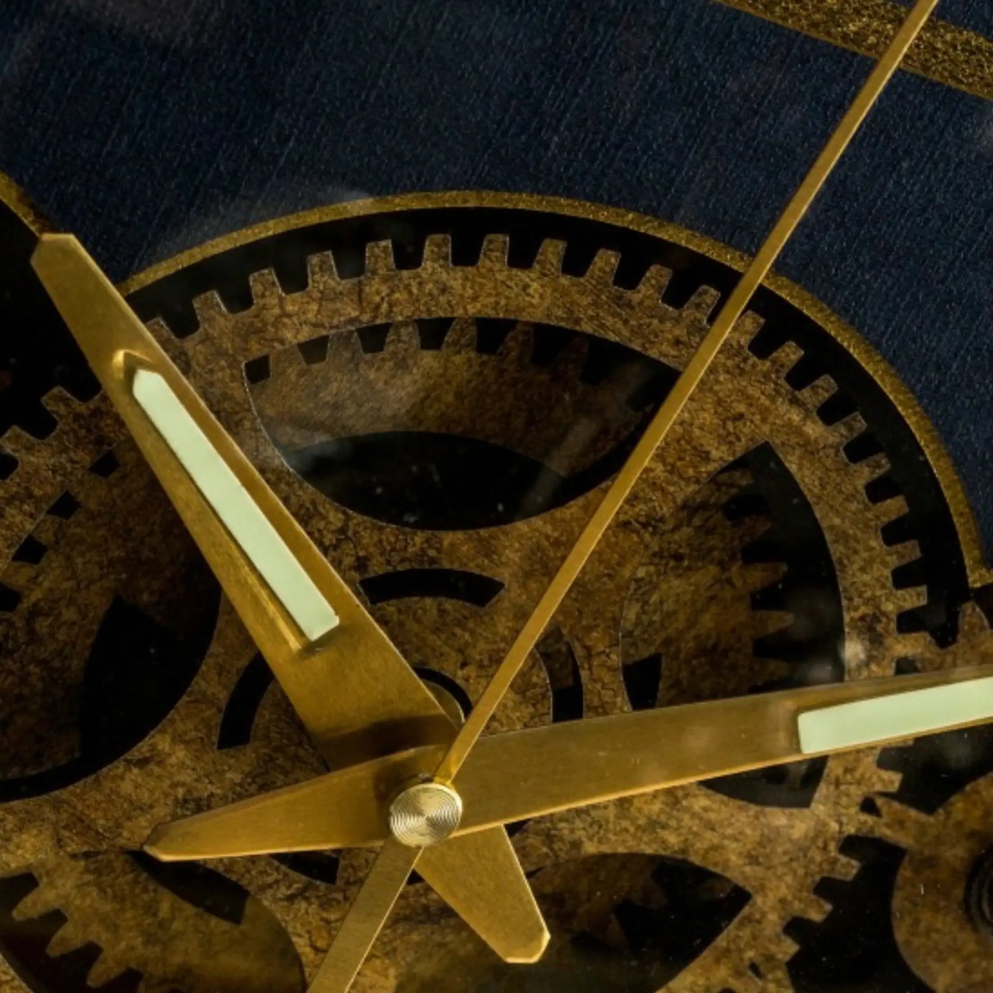 Close-up of mechanical clock gears with gold hands on a dark background