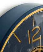 Close-up of a clock with gold numbers and hands on a dark blue background