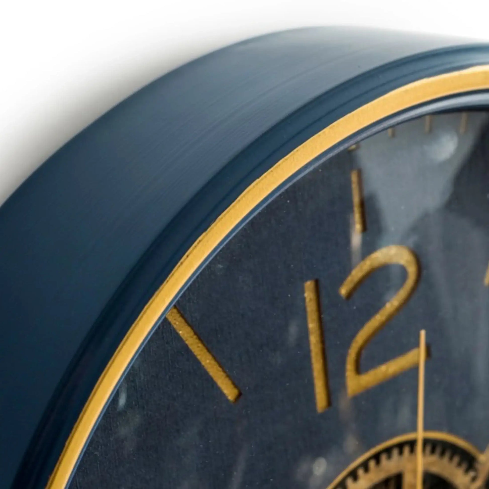 Close-up of a clock with gold numbers and hands on a dark blue background