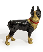 Vintage cast iron dog doorstop with black and gold coloring on a white background