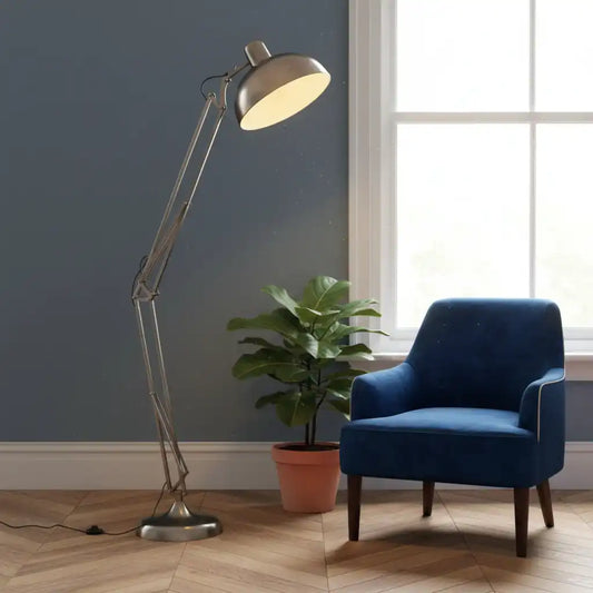 Blue armchair next to a floor lamp and potted plant in a room with a window.