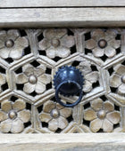 Decorative wooden panel with floral patterns and a metal knocker.