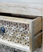 Wooden drawer with intricate carvings and a floral pattern.