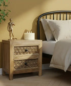 Bedroom with wooden nightstand, bed with white bedding, and decorative items.