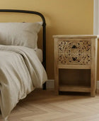 Bedroom with a bed and wooden nightstand against a yellow wall.