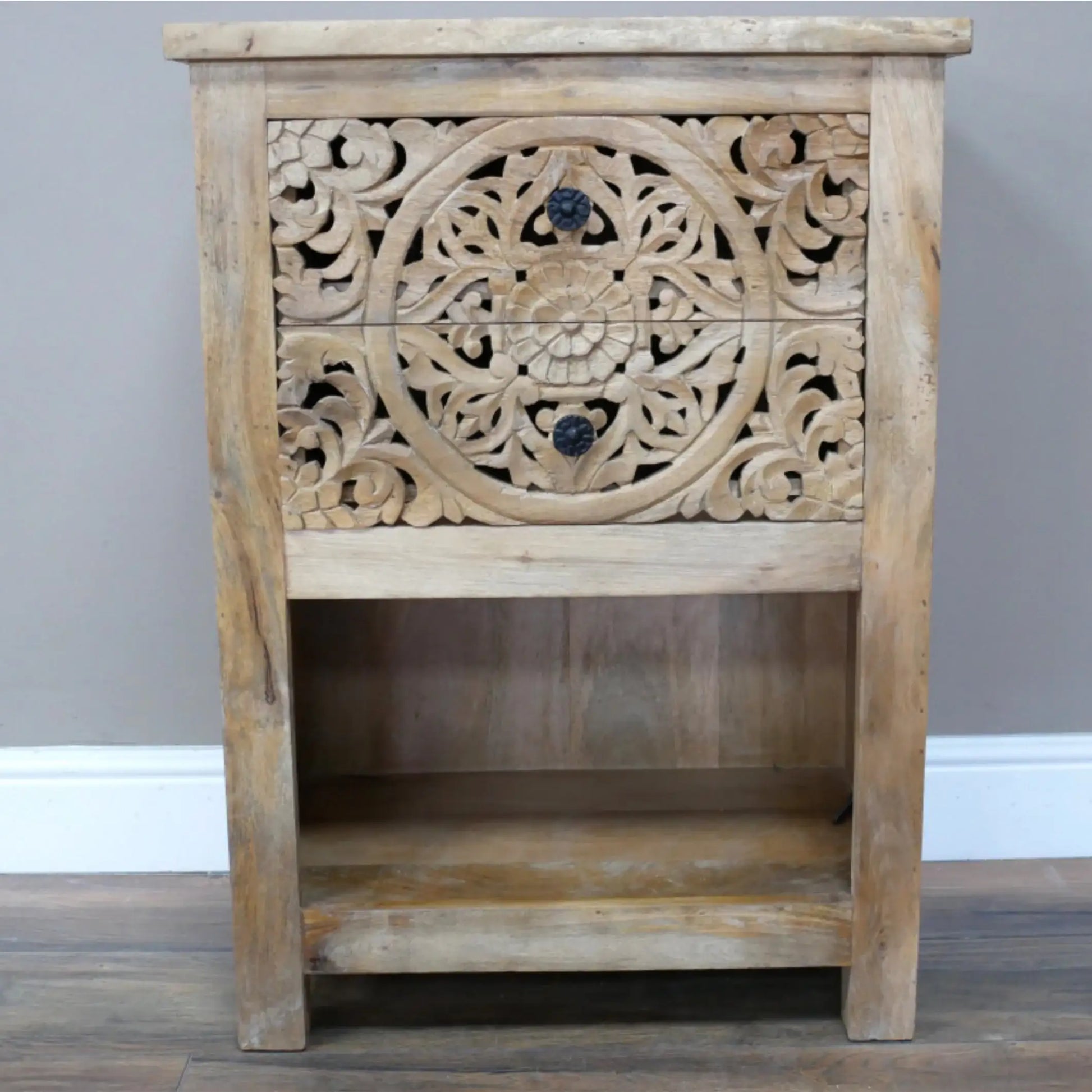 Wooden side table with intricate carvings on a plain background