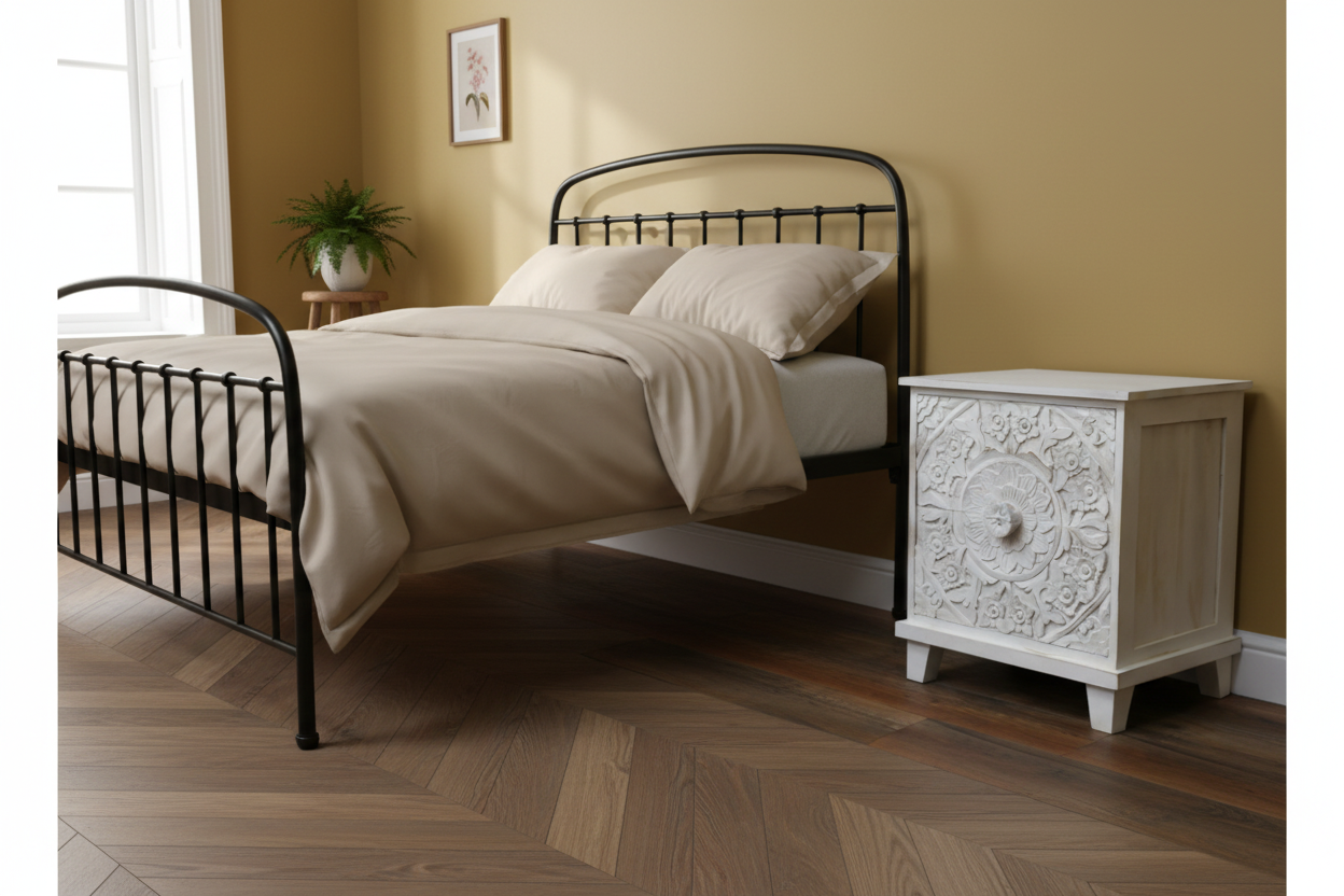 Bedroom with a black metal bed and white nightstand against a beige wall.