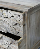 Wooden drawer with intricate carvings on a wooden cabinet