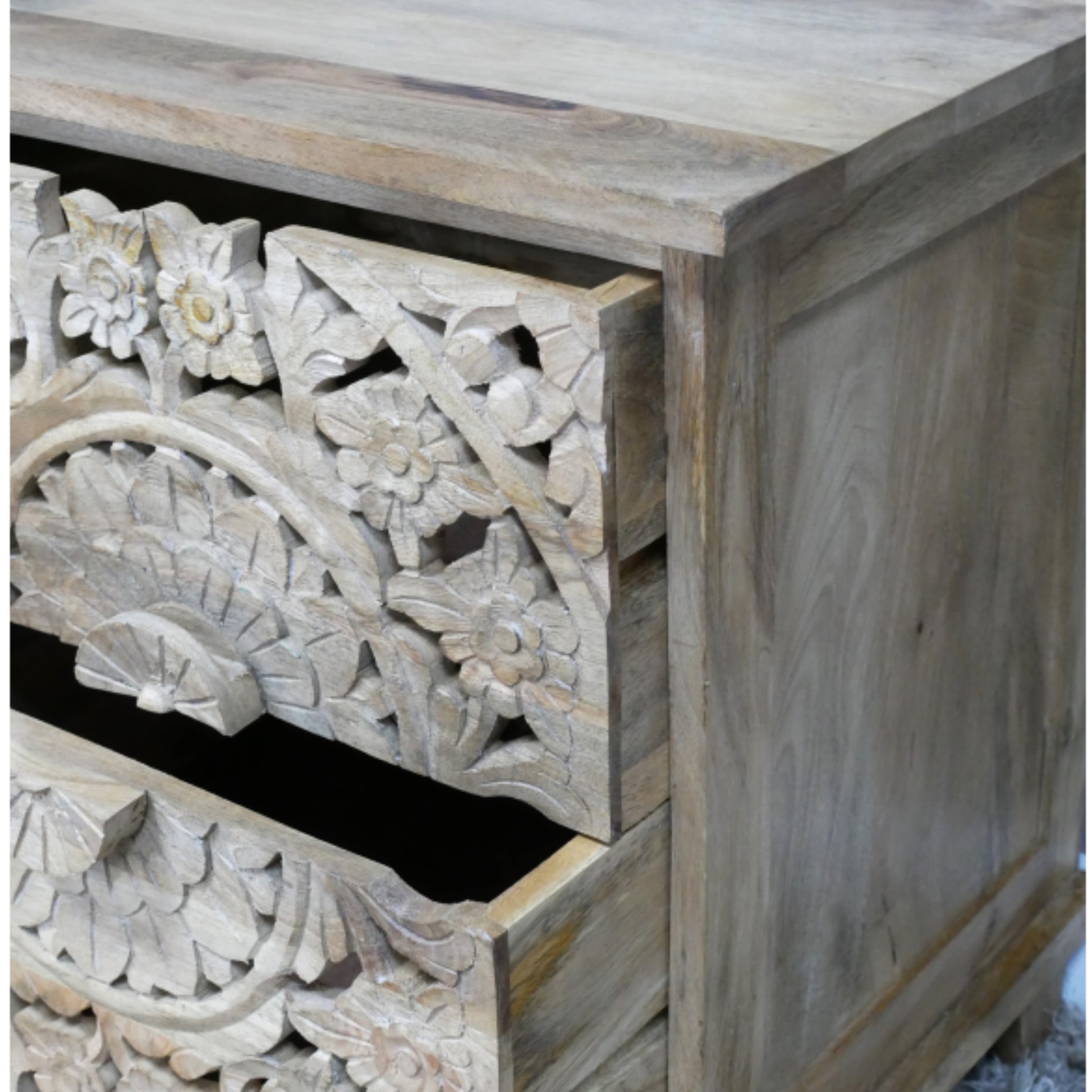 Wooden drawer with intricate carvings on a wooden cabinet