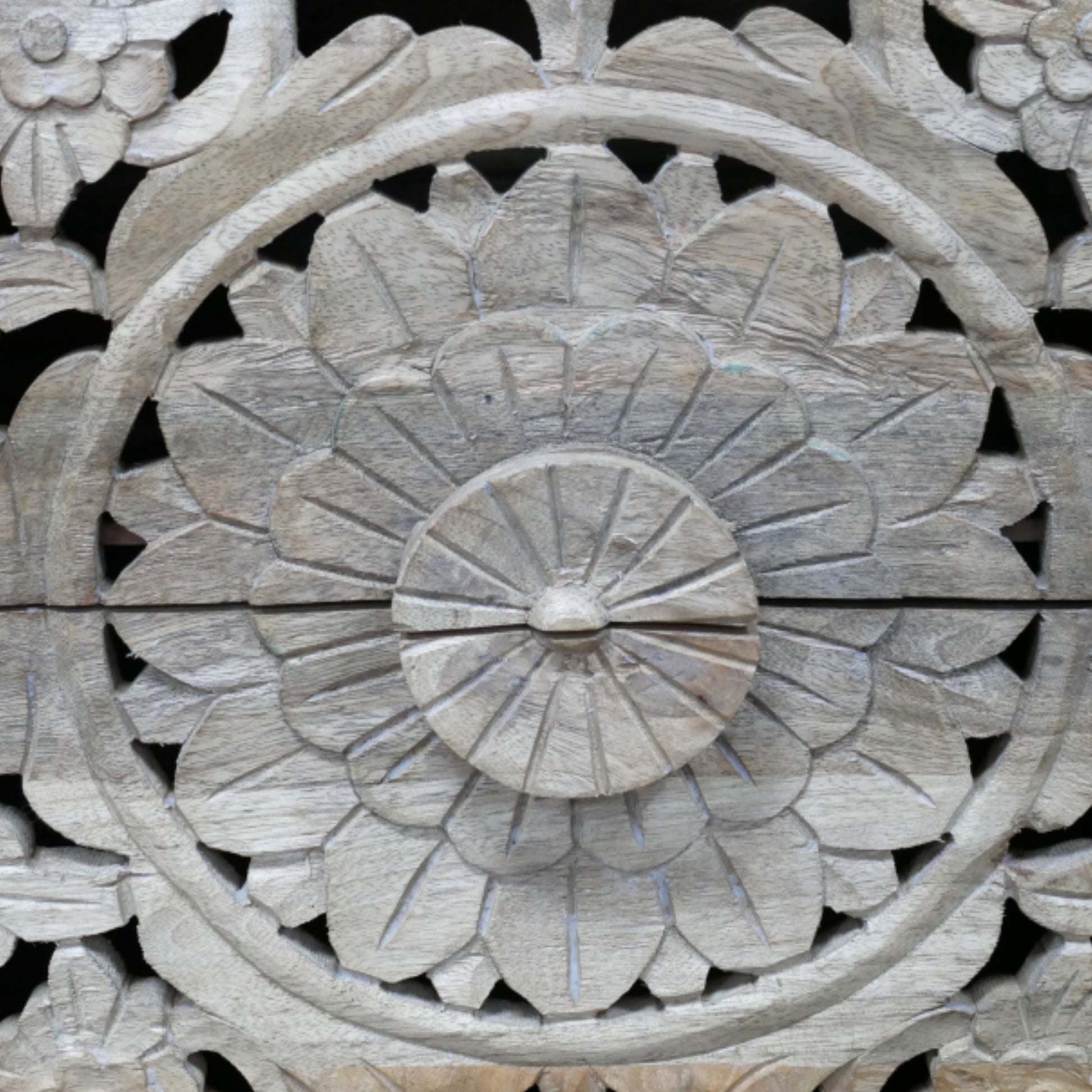 Close-up of a wooden carvings with floral patterns on a black background