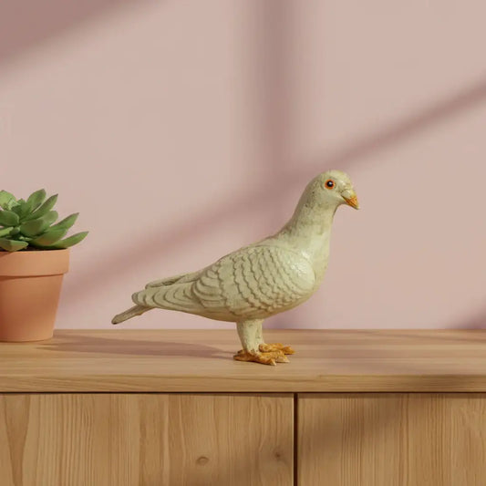 Decorative pigeon figurine on a wooden surface with a pink background