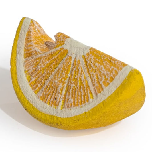 A ceramic sculpture shaped like a stylized orange slice, featuring textured yellow-orange segments, a thick yellow rind, and a white pith center, displayed on a clean white background.