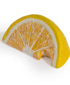 A yellow and orange citrus wedge sculpture or decorative object with textured orange segments and a bright yellow rind, shown on a plain white background.