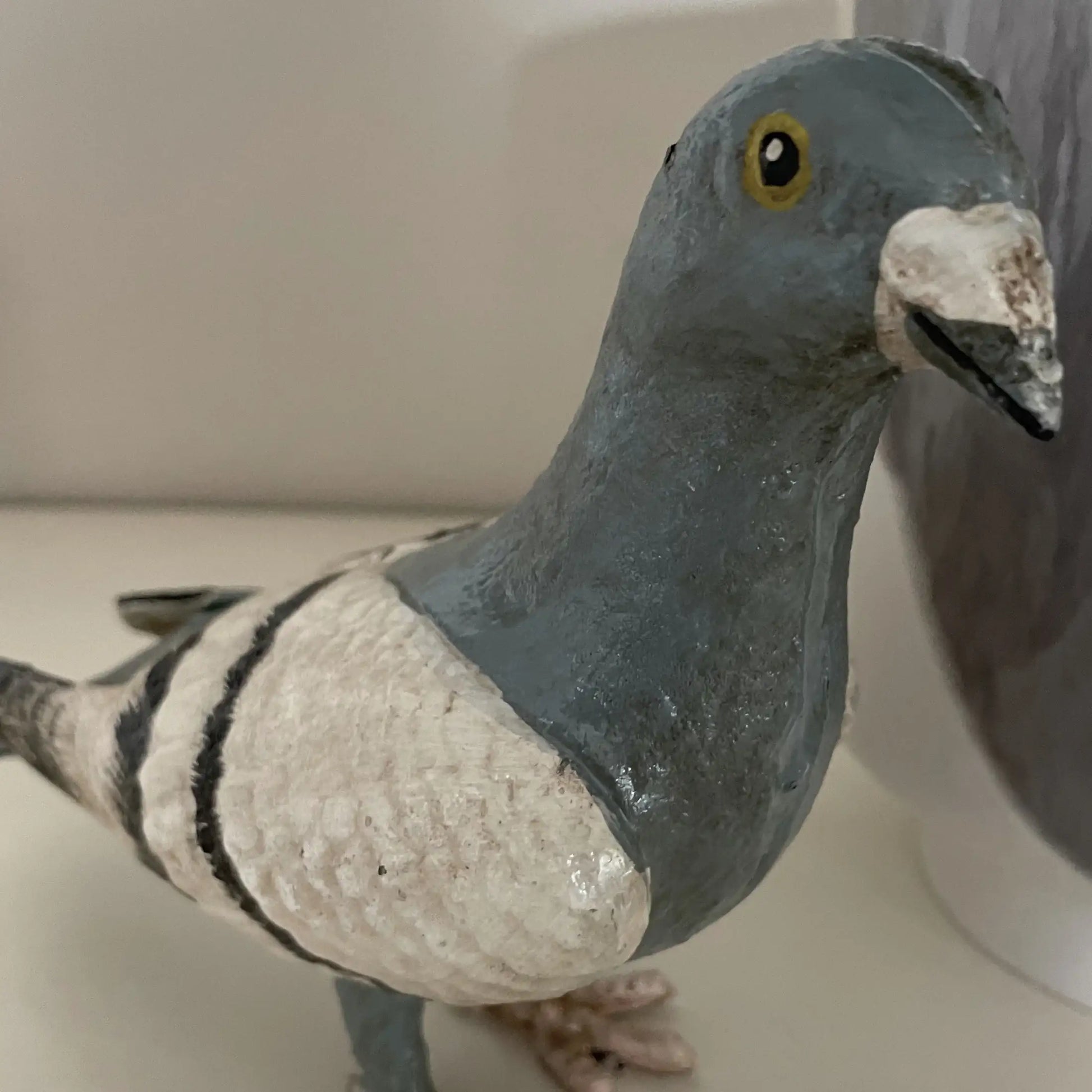 Statue of a pigeon on a plain background