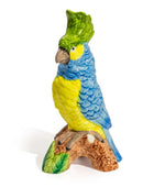 Colorful parrot figurine on a branch with a white background
