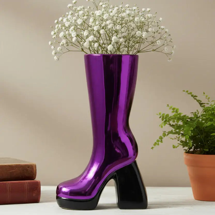 Purple boot-shaped vase with white flowers on a neutral background