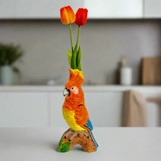 Colorful parrot figurine with tulips on a white background