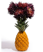 Pineapple-shaped vase with dark purple flowers on a white background