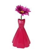 Pink dress-shaped vase with a single pink flower on a white background